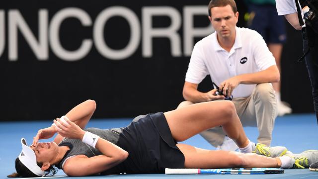 Muguruza, acalambrada en el suelo de la pista de Brisbane.