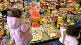 Dos niñas observan un escaparate lleno de juguetes, en una imagen de archivo.