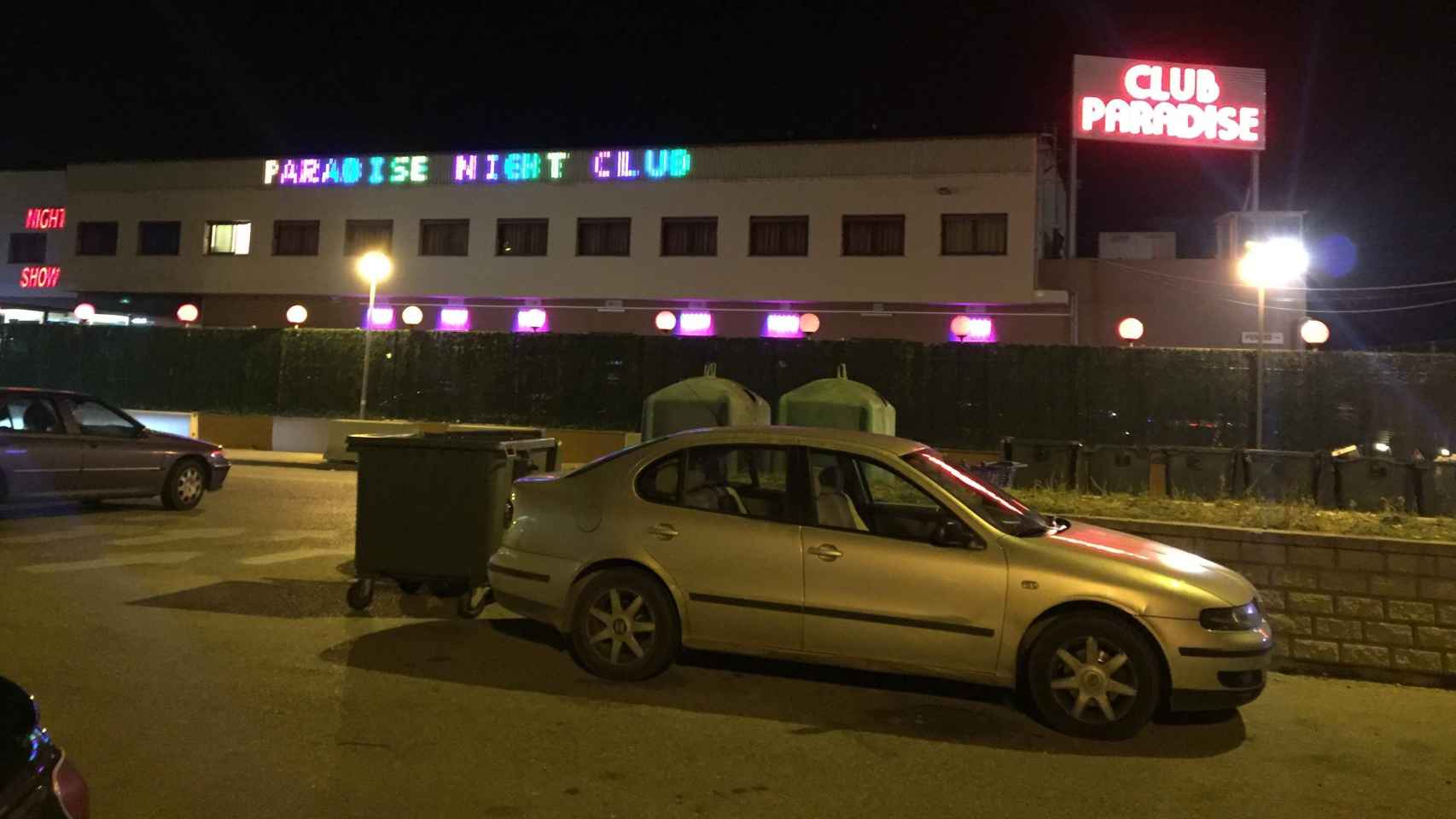 Fachada principal del club Paradise con los coches de los clientes aparcados delante.