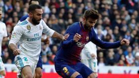 Gerard Piqué protege el balón frente a Carvajal.