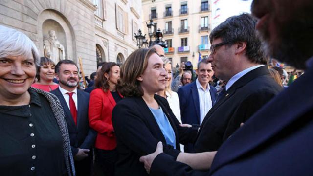 La alcaldesa de Barcelona, Ada Colau, y el presidente de la Generalitat, Carles Puigdemont, se saludan.