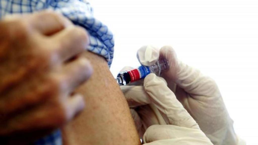 Un médico aplica la vacuna de la gripe.