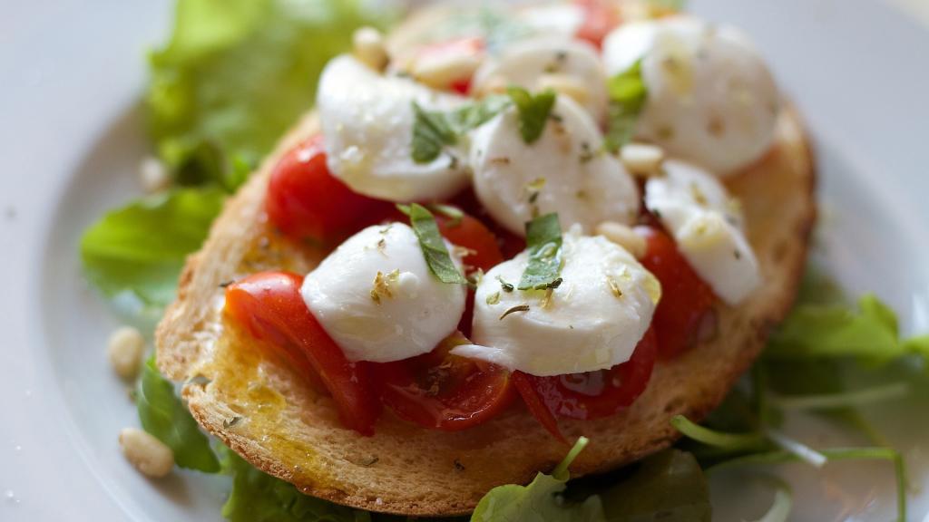 Una apetitosa rebanada de pan con tomate y queso fresco.