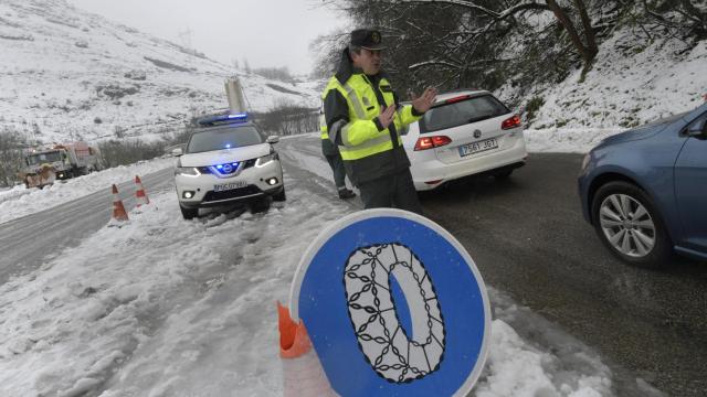 Un guardia civil da indicaciones a los vehículos que intentan atravesar el puerto de Pajares.