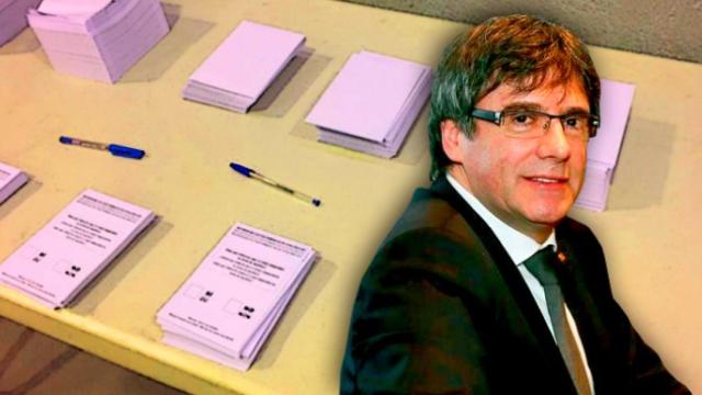 Una mesa con papeletas en el 1-O tras el expresidente, Carles Puigdemont.