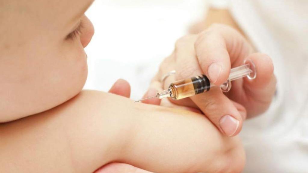 Un médico vacuna a un niño pequeño contra el sarampión.