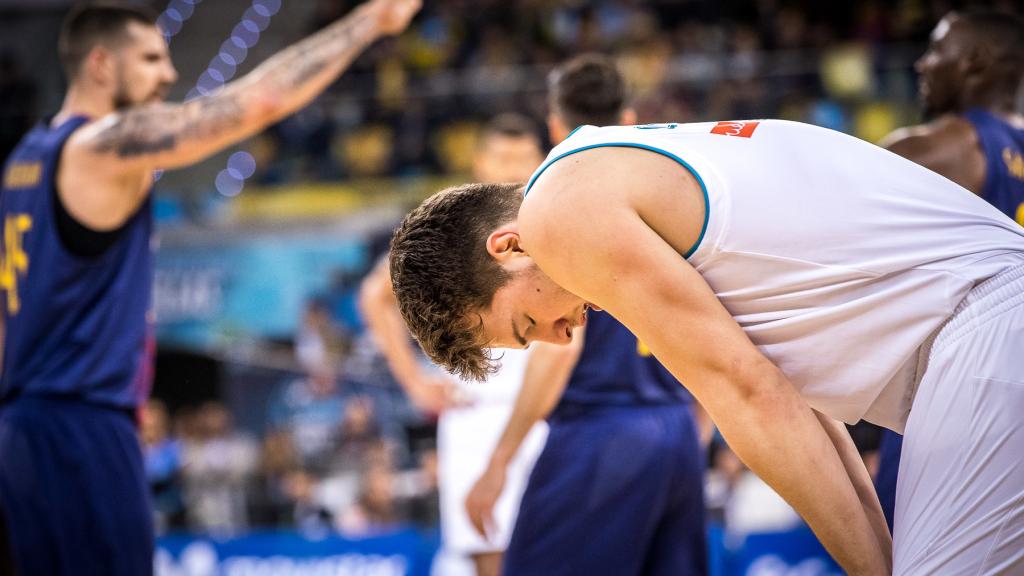 Luka Doncic apenado mientras el Barça celebra una canasta.