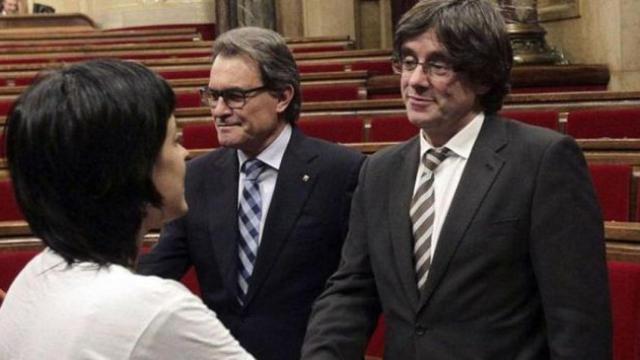 Anna Gabriel (de espaldas) saluda a Carles Puigdemont en presencia de Artur Mas en el Parlament.