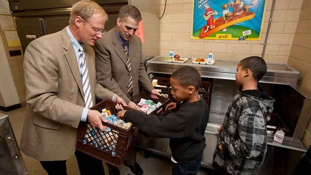 Brian Wansink (a la izquierda) entrega alimentos a unos niños
