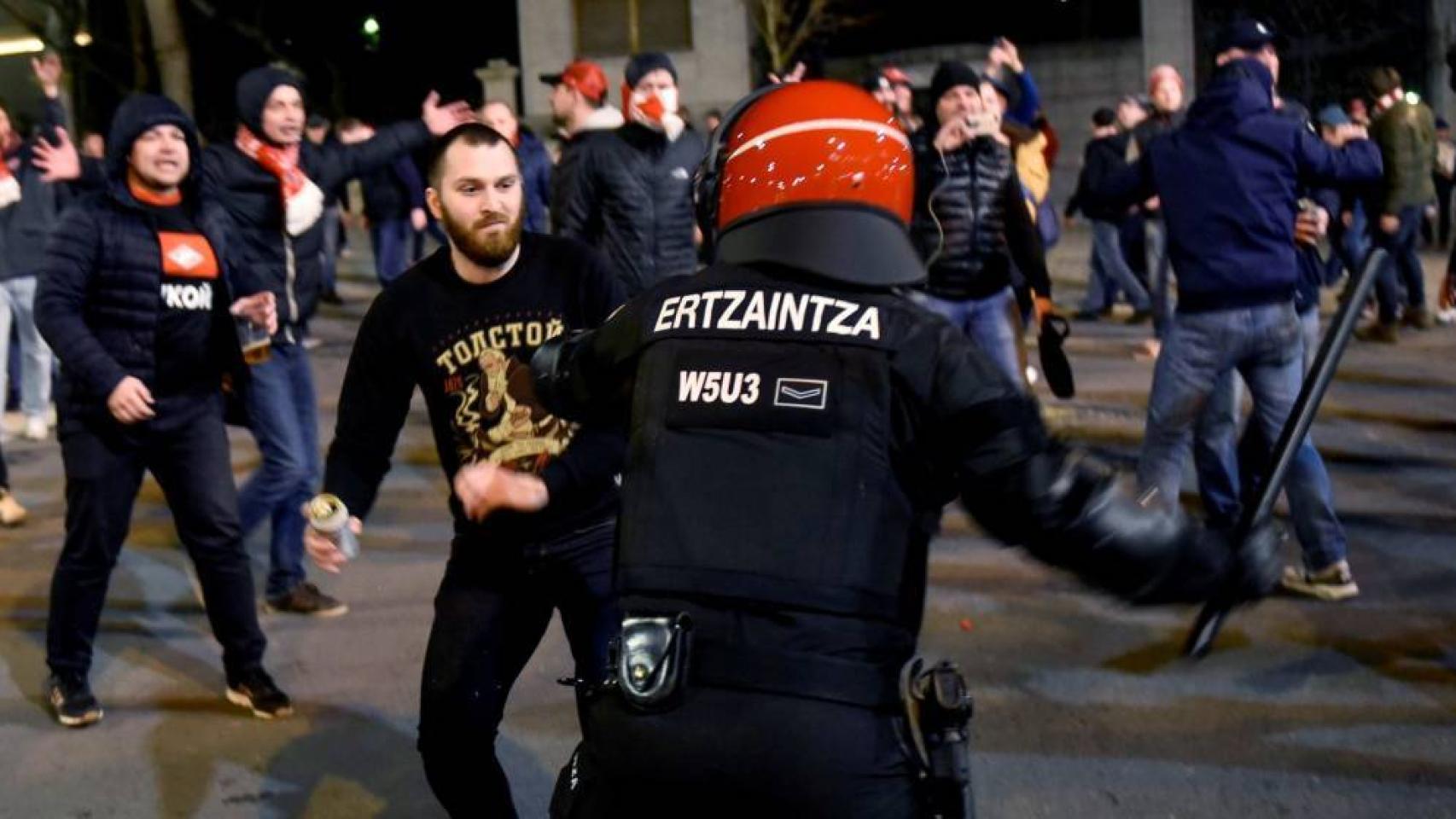 Un ertzaina trata de parar a uno de los ultras antes del partido entre Athletic y Spartak.