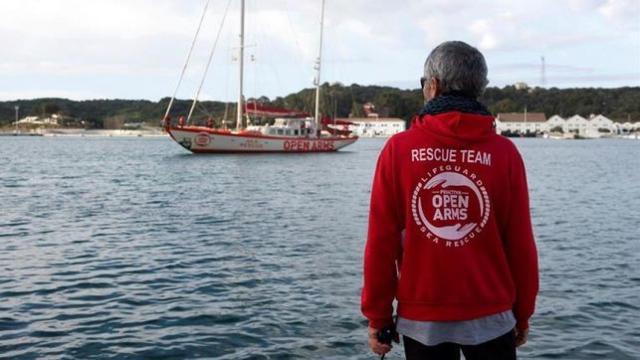 El barco español 'Open Arms' y uno de sus trabajadores.