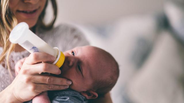 Una madre da el biberón a su niño recién nacido.