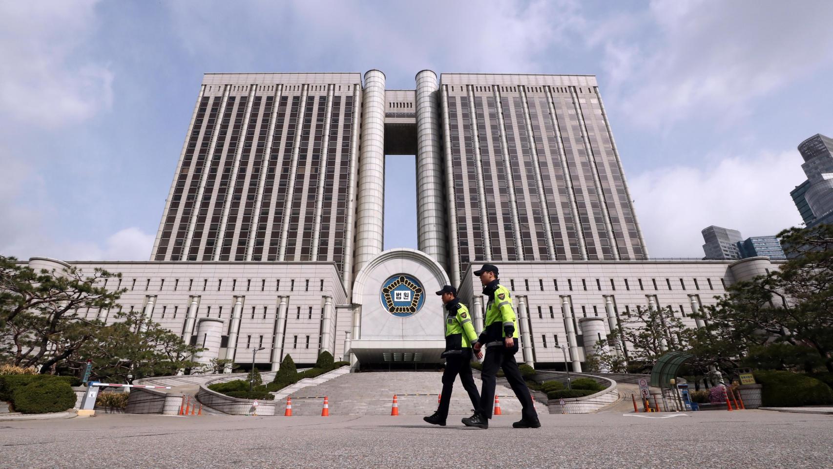 Varios policías patrullan el exterior del Tribunal del Distrito Central de Seúl, previo a la audiencia de sentencia para la expresidentaPark Geun-hye.