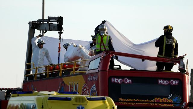 Los servicios de emergencia retiran un cadáver del autobús.