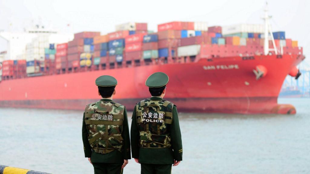 Dos guardias fronterizos mientras hacen guardia en un puerto en Qingdao (China).
