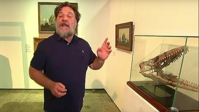 Russell Crowe junto al cráneo de dinosaurio que sacó a subasta.