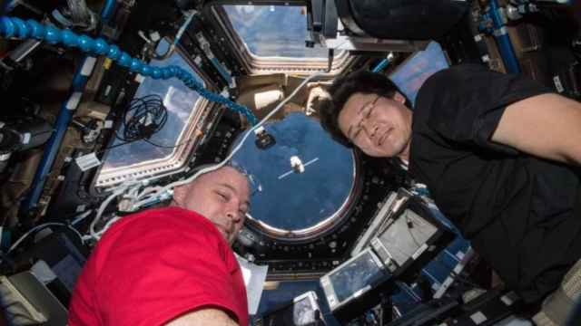 Los astronautas Scott Tingle (izquierda) y Norishige Kanai (derecha) en el interior de un cohete de la NASA.