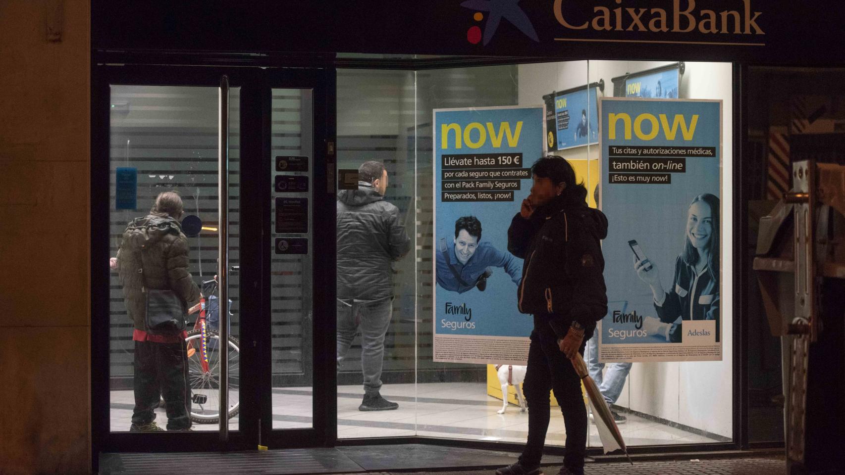 Varias personas esperan en un cajero de una entidad bancaria el ingreso de la ayuda social del Estado. Este pasado lunes, 9 de abril, se produjeron colas pocos minutos antes de dar las doce de la noche y el comienzo del 10 de abril, día de cobro.