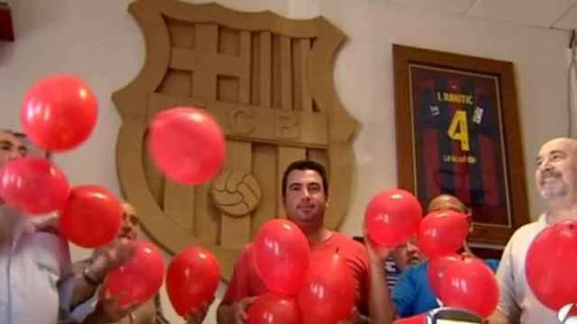 Peñistas del Barcelona en Sevilla con los globos rojos.