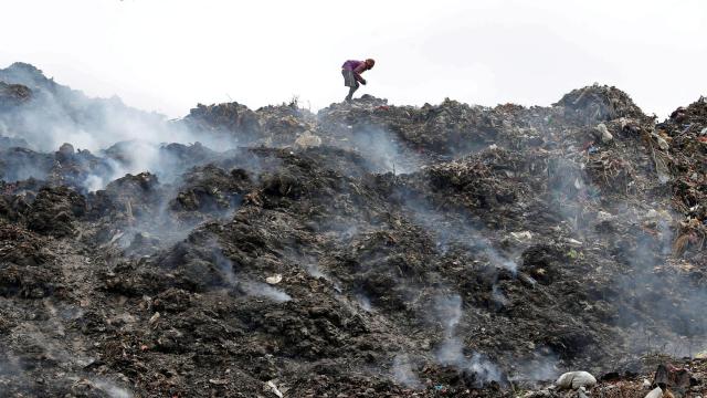 Un hombre rebusca desperdicios en un vertedero con fuegos activos en Calcuta. REUTERS/Rupak De Chowdhuri.