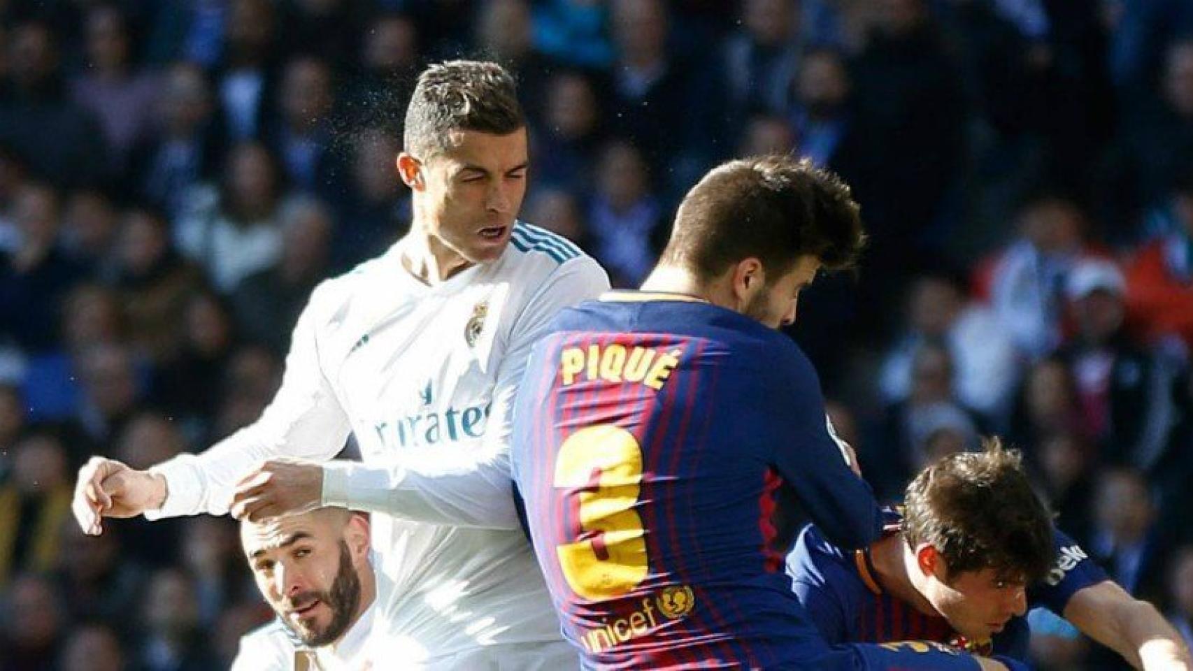 Cristiano lucha un balón con Piqué