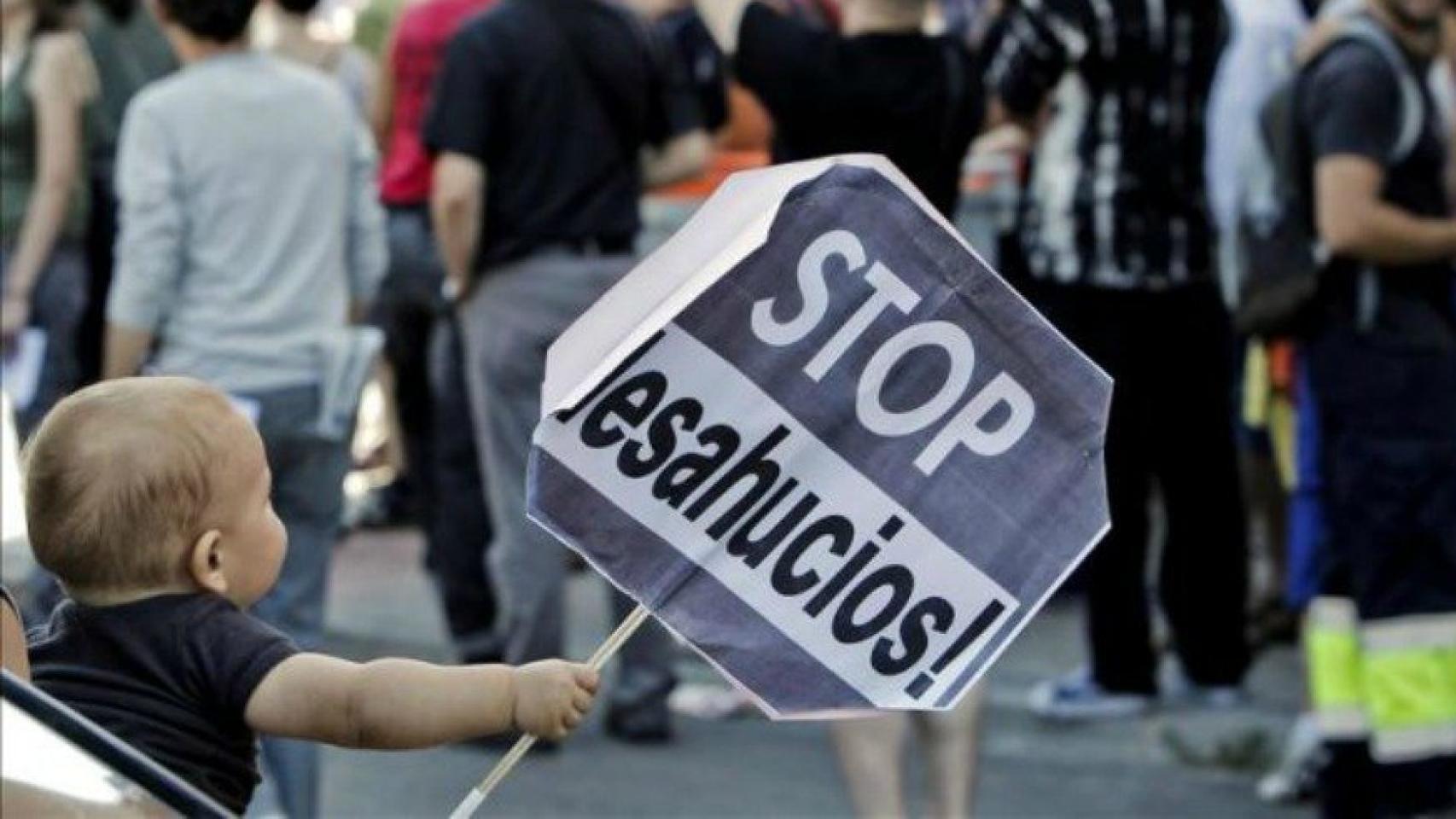 Un niño sostiene una pancarta en una manifestación contra los desahucios.