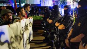 Miembros de los CDR, frente a un grupo de Mossos, en un acto de Barcelona.