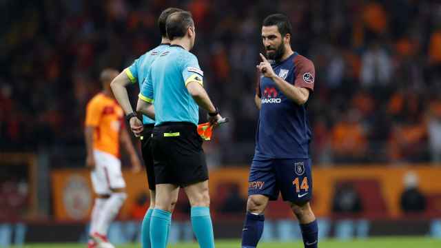 Turan habla con un árbitro durante un partido.