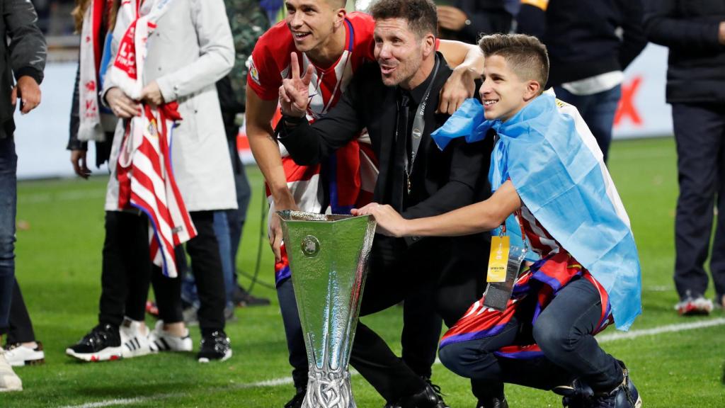 Simeone posa junto a la Europa League con su familia.