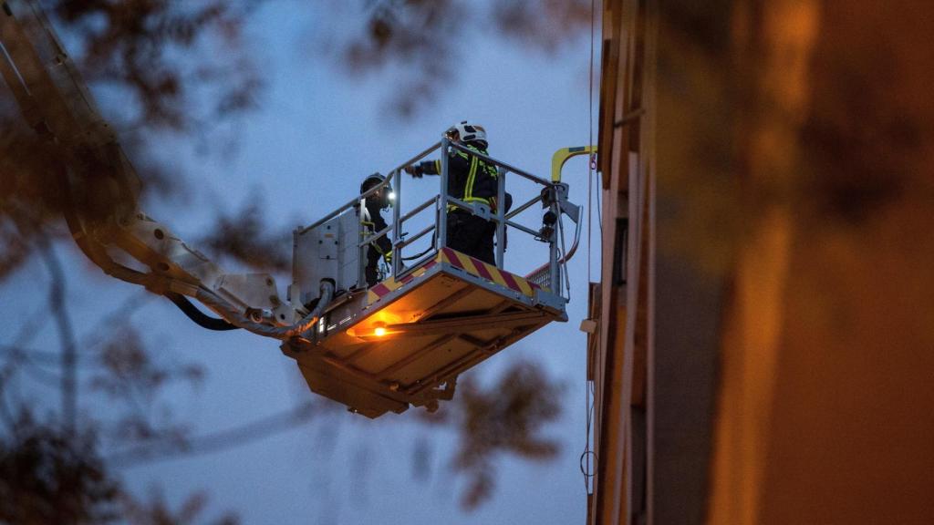 Unos bomberos trabajan junto al edificio que se ha derrumbado.