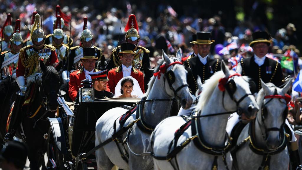 Los recién casados desfilando en el coche de caballos.