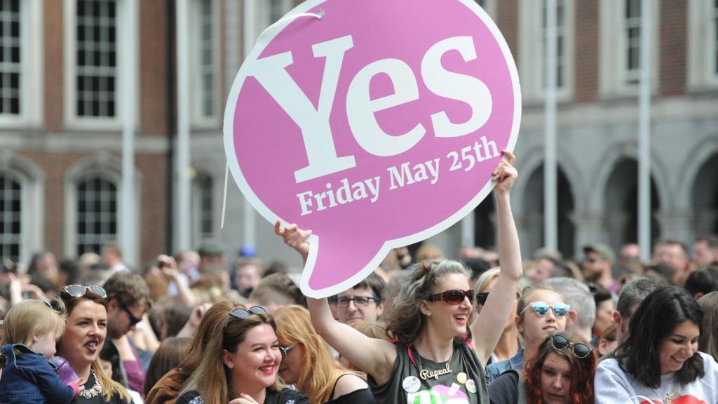 Una mujer muestra un cartel en el que se puede leer 'Sí' en el referéndum sobre el aborto en Irlanda.