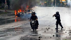 Un agente de antidisturbios dispara a un manifestante en Managua