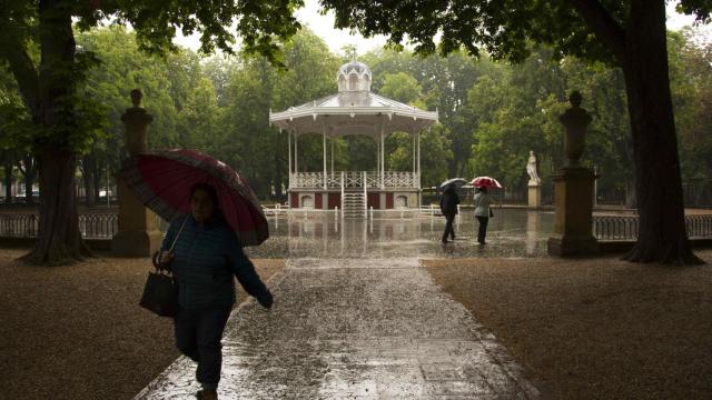 Paseantes se protegen de la lluvia en el parque de la Florida de Vitoria (archivo).