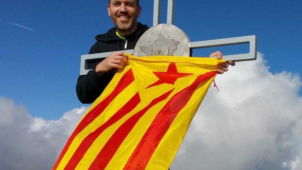 Costa posa, en plena montaña, con una estelada.