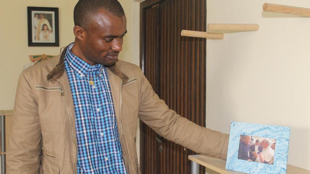 Modou muestra una imagen del papa Francisco junto al sacerdote gaditano Gabriel Delgado, que le regaló la 'patera' del senegalés.