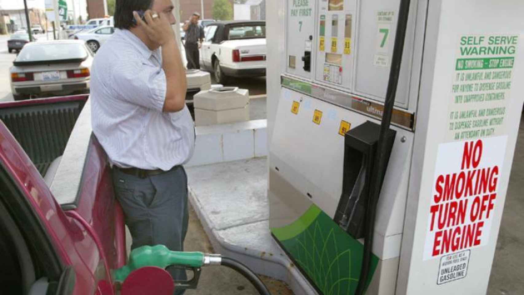 Usuario usando un móvil en una gasolinera.