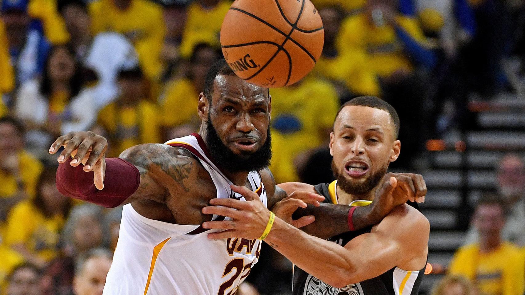 LeBron James y Stephen Curry pugnan durante una jugada.