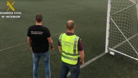 Dos miembros de la Guardia Civil en un campo de fútbol.