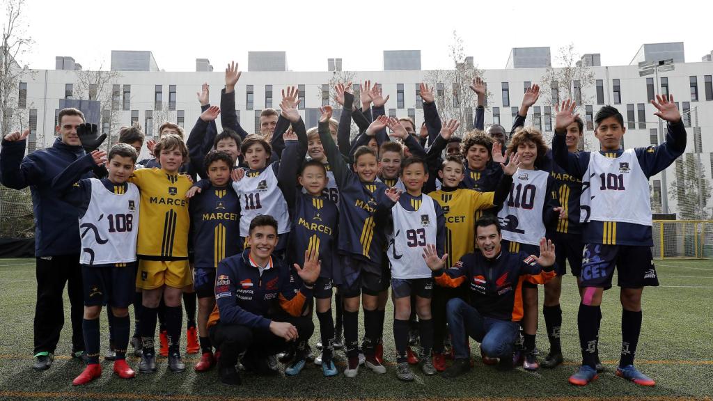 Márquez y Pedrosa, con los niños con los que han compartido un partido de fútbol.