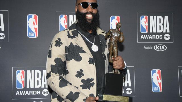 James Harden y su traje posan con el MVP de la temporada regular.