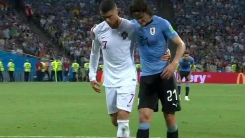 Cristiano ayuda a Cavani a salir del terreno de juego.