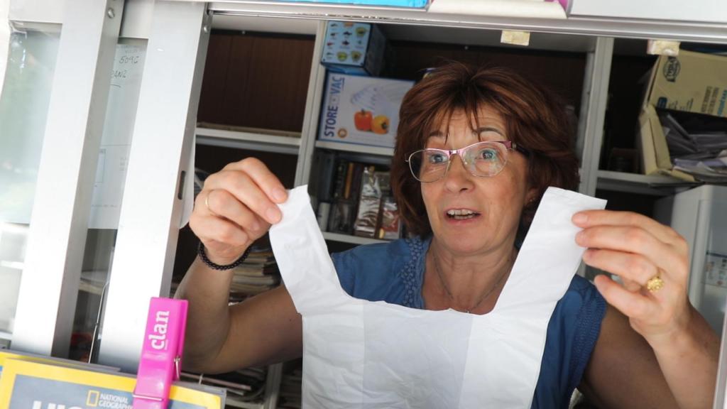 La encargada de una tienda muestra una bolsa de plástico.