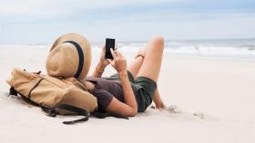 Una trabajadora contesta una llamada de la empresa en la playa.