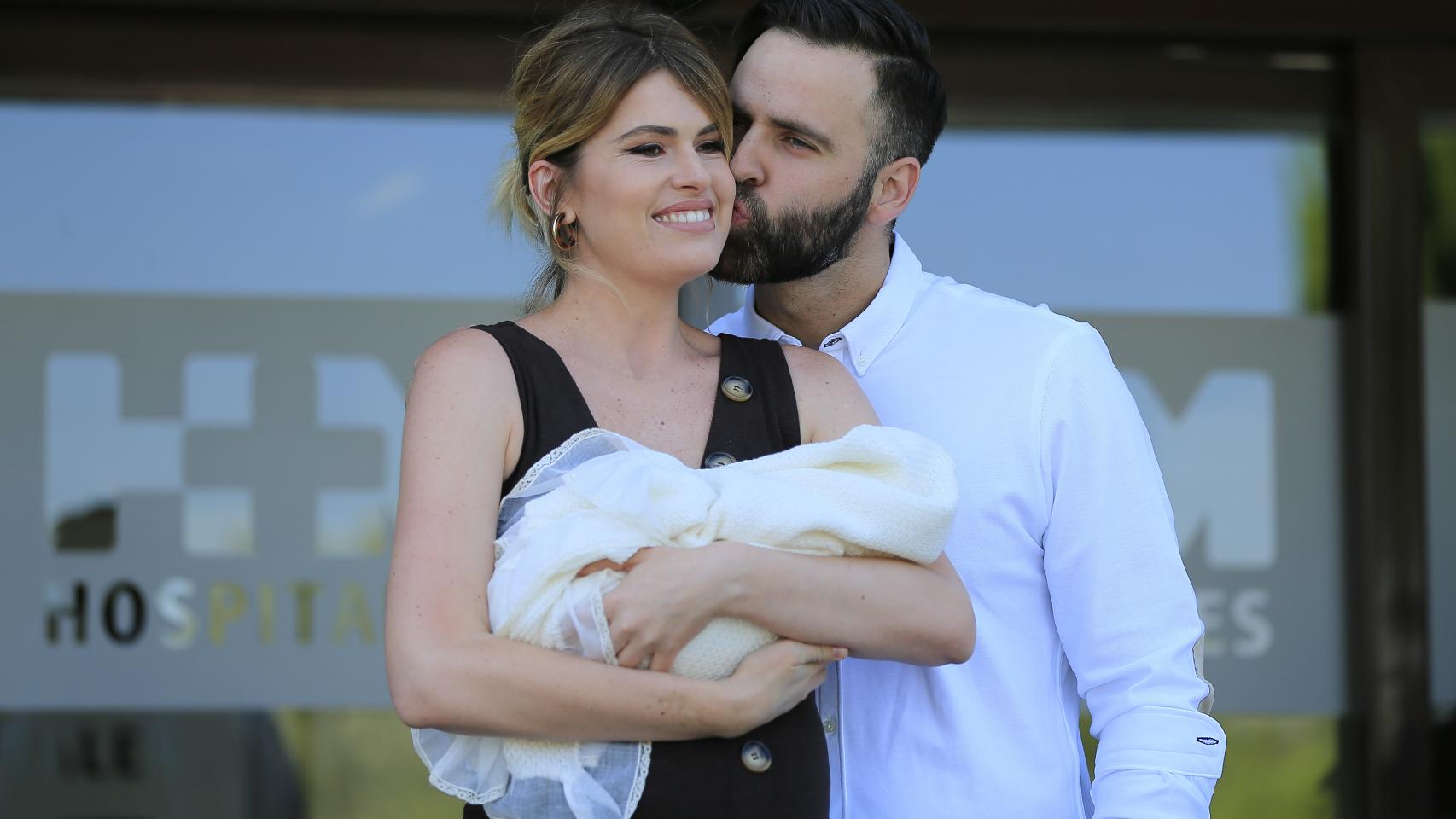 Adriana Abenia junto a su pareja en la presentación oficial del recién nacido.