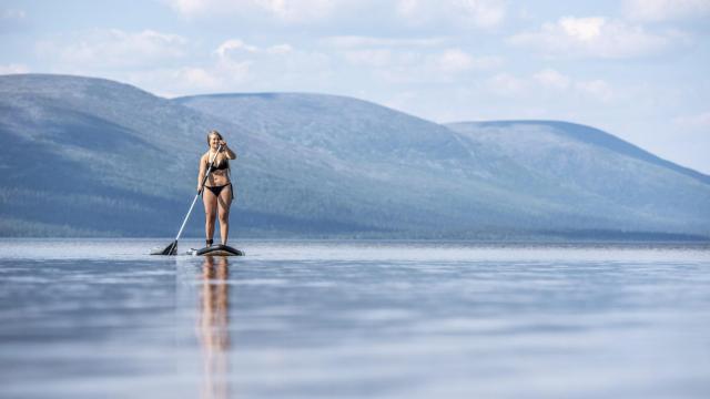 Una joven disfruta del calor en Laponia, Finlandia.