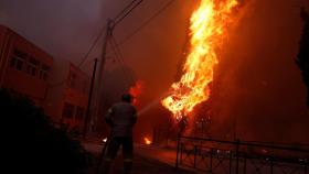 Un bombero intenta extinguir las llamas en la ciudad de Rafina, cerca de Atenas.