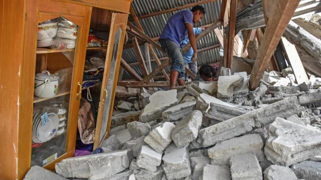 Un hombre, entre las ruinas de su casa, en la isla de Lombok.