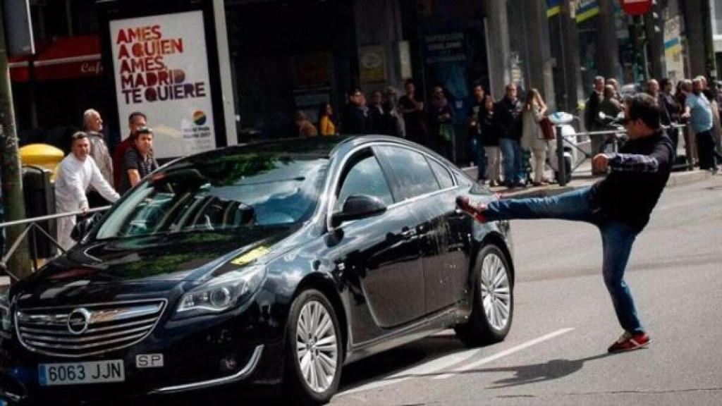 Un taxista en huelga propina una patada a un coche con licencia VTC en Madrid