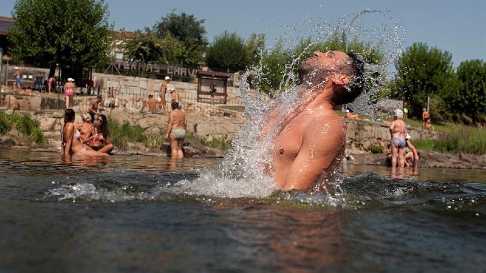 Un hombre se refresca en la zona fluvial del río Miño y las termas de A Chavasqueira, en Orense.